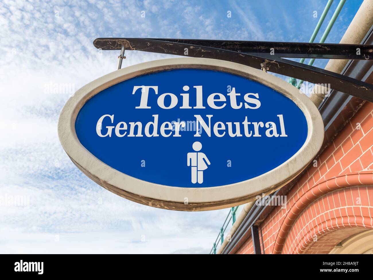 Aufhängeschild für öffentliche Toiletten für geschlechtsneutrale oder geschlechtsfreie Menschen. Fiktives Zeichen, digital vom Original verändert. Stockfoto