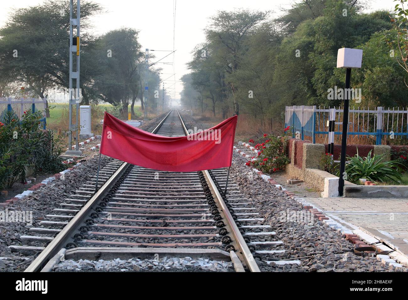 Ein rotes Tuch blockiert die Bewegung eines Zuges. Verbot des Zugverkehrs. Haryana, Indien Stockfoto