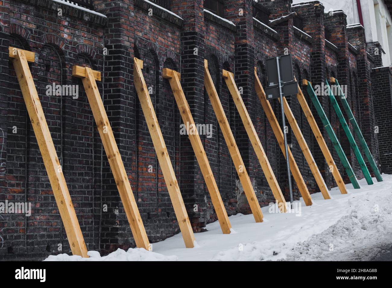 Lublin, Polen - 13. Februar 2021: Holzstützen an der Wand in der Dolna Panny Marii Straße im Winter Stockfoto
