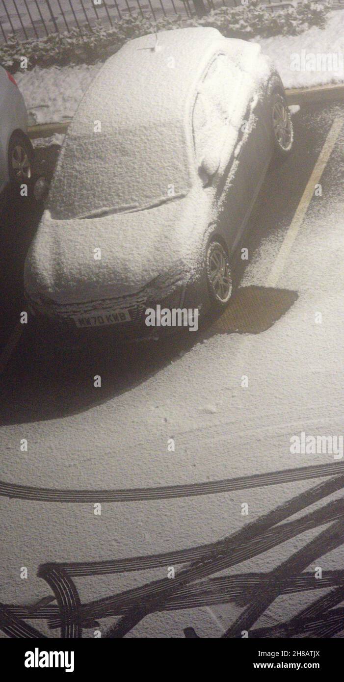 Auto mit Schnee bedeckt, das neben Reifenspuren im Schnee in Manchester, Großbritannien, England, Großbritannien, am 28th. November geparkt ist, 2021, am ersten kalten Snap des Jahres, da die Temperatur -3C in der Nacht bei nebligen Bedingungen ist. Stockfoto