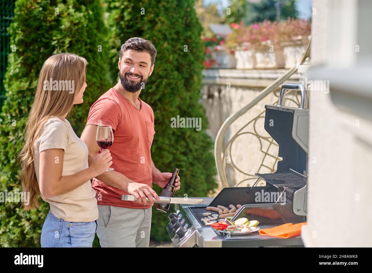 Ein junges Kind kocht zusammen gegrilltes Gemüse und schaut glücklich aus Stockfoto