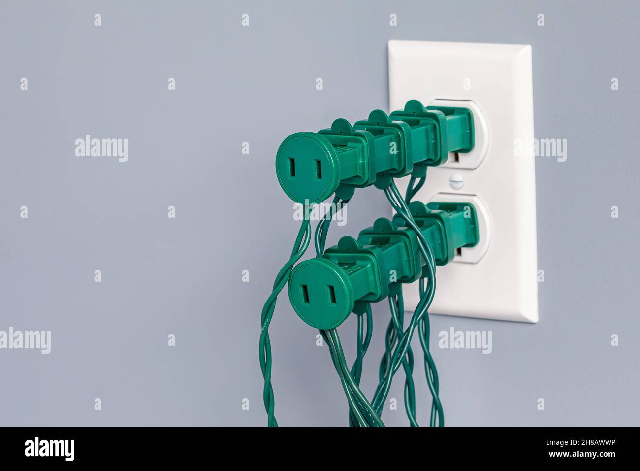 Steckdose mit Weihnachtsbeleuchtung überlastet. Design-Konzept für Sicherheit, Gefahren und Brandschutz. Stockfoto