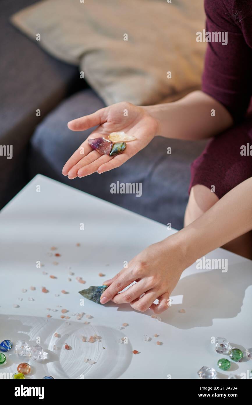 Erfahrene Heilerin, die einen Heilstein auswählt Stockfoto