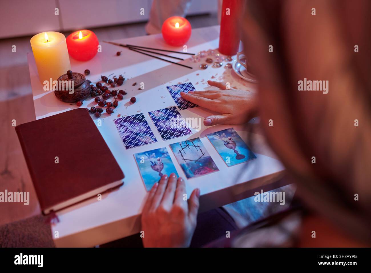 Geheimnisvoller Wahrsager, der eine Tarot-Karte liest Stockfoto