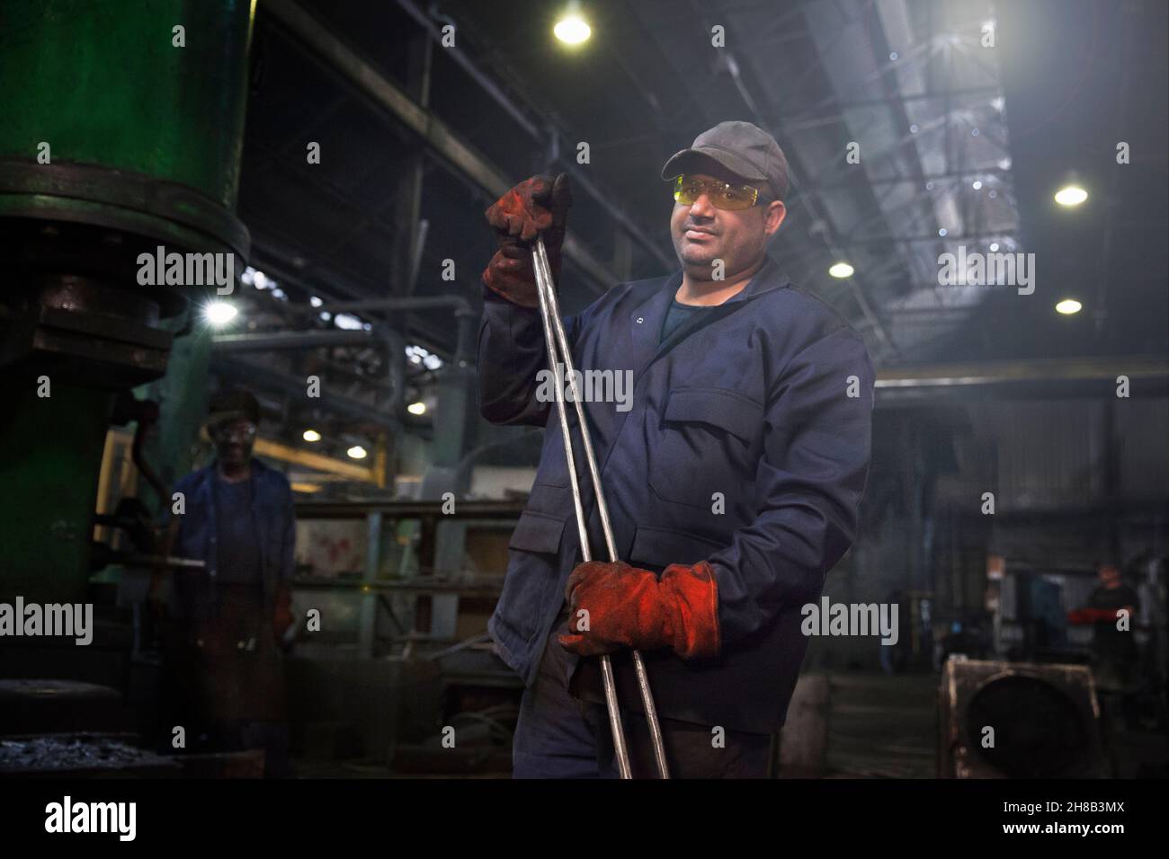 Arbeiter für die Aktion mit einer Reihe von industriellen Zange grundiert zu schmieden Stockfoto