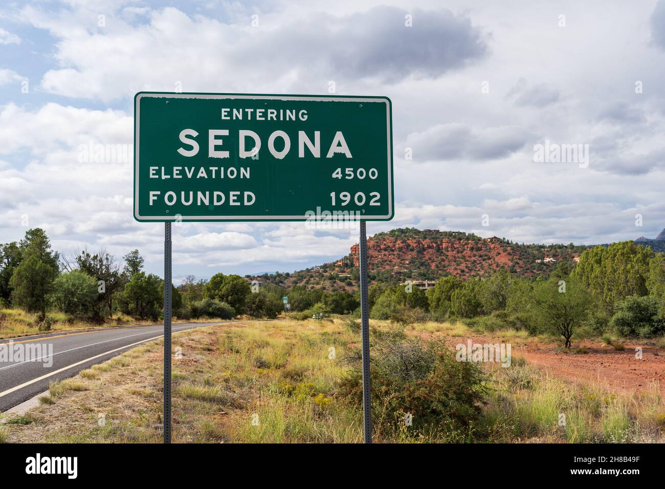 Beim Betreten von Sedona Elevation 4500 und gründete 1902 Schild mit Straße und Landschaft im weichen Fokus dahinter Stockfoto