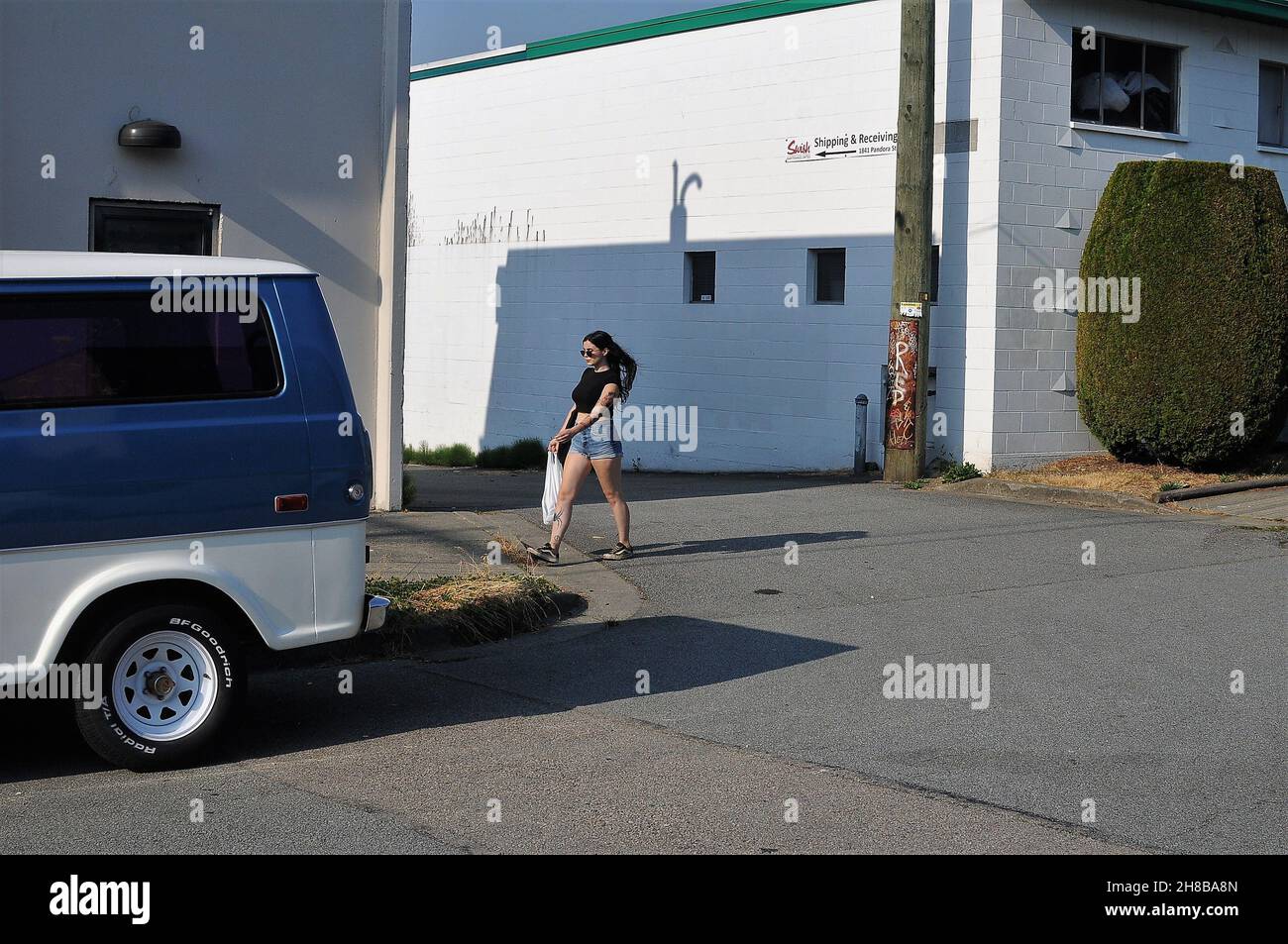 Eine Einheimische, die durch ein Industriegebiet im Osten von Vancouver spazierengeht Stockfoto