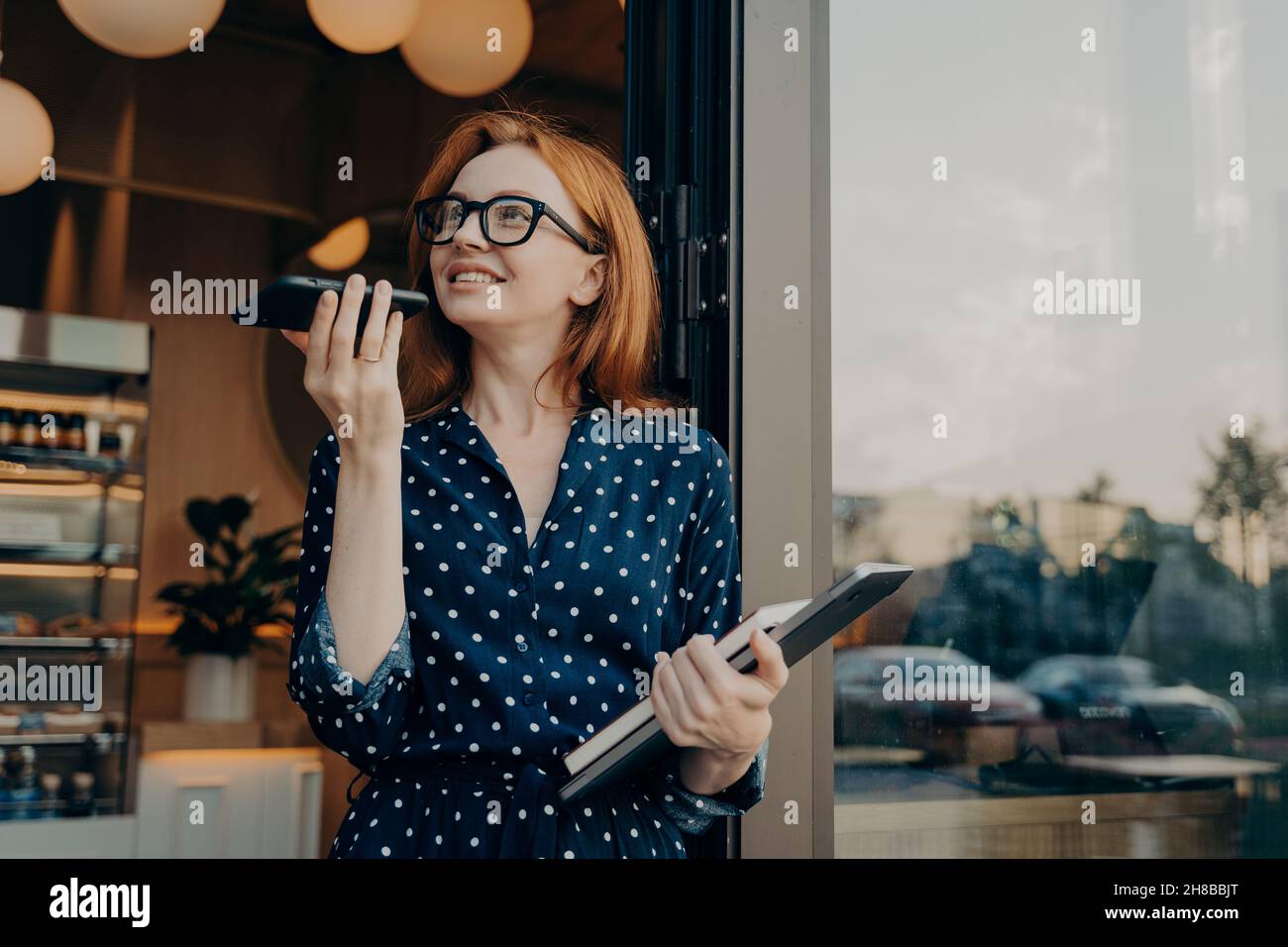 Pretty Woman spricht über den Lautsprecher über das Smartphone zeichnet Sprachnachrichten auf Stockfoto
