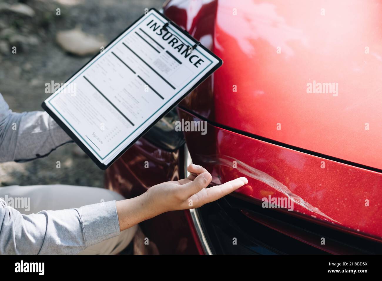 Mann Agent Überprüfung des beschädigten Autos und untersucht es, Verkehrsunfall und Versicherungskonzept. Stockfoto