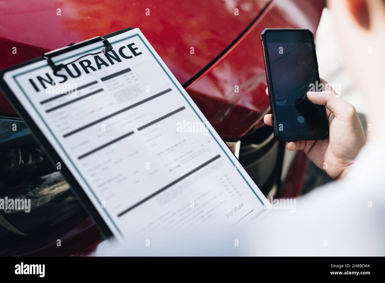 Man Agent macht eine Momentaufnahme des beschädigten Autos und untersucht es, Verkehrsunfall und Versicherungskonzept Stockfoto