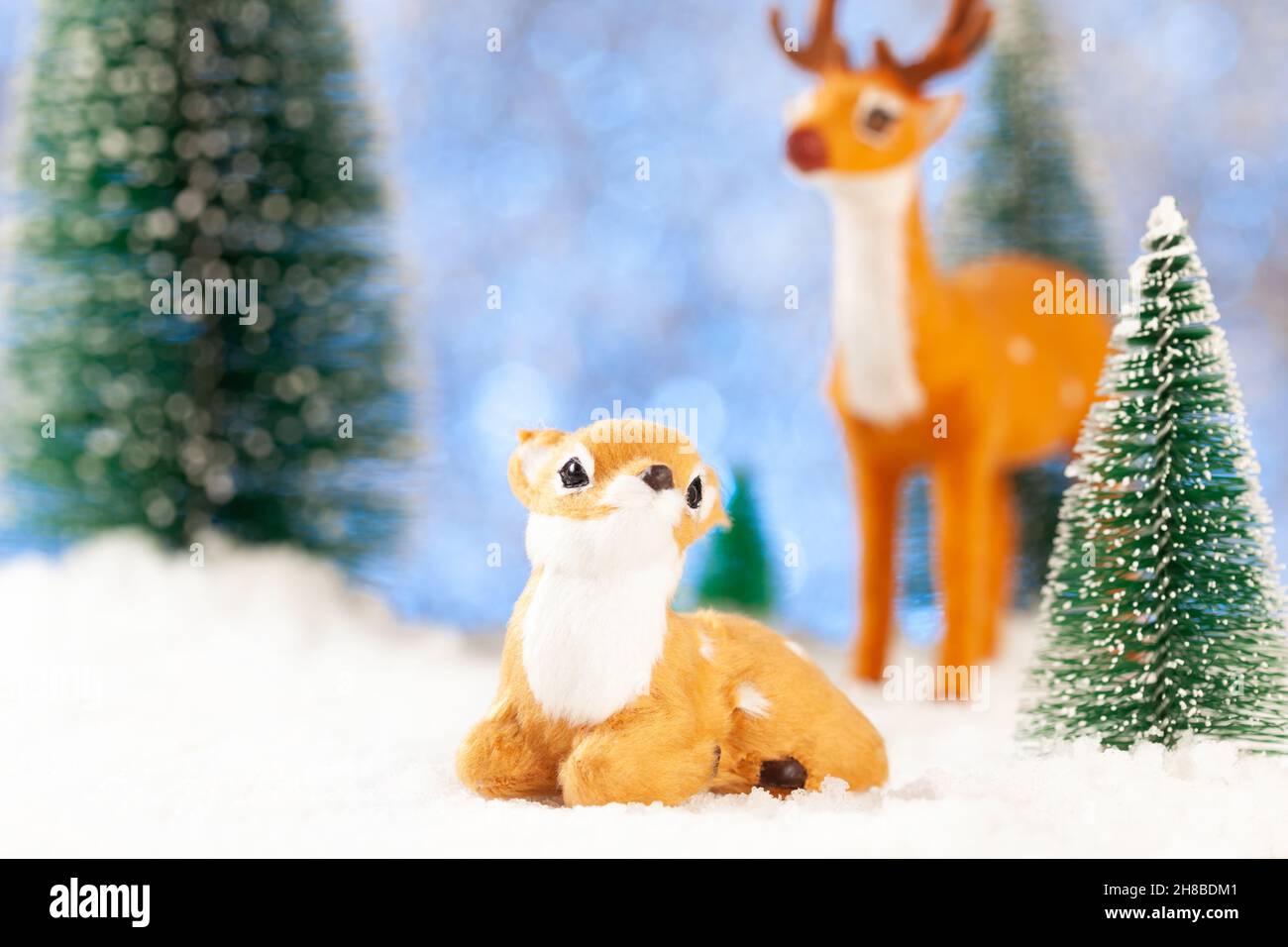 Begrüßung der Jahreskarte, zwei kleine Spielzeughirsche im Schnee Stockfoto