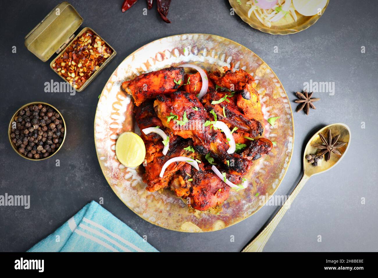 Tandoori-Huhn ist ein beliebtes Rezept für gebratenes Huhn aus Indien. Tandoor ist ein traditioneller Holzofen. Chicken Tandoori Platter wird auf einem schwarzen Teller serviert Stockfoto