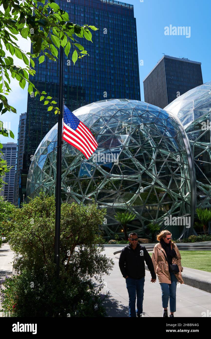 Die Menschen laufen an Amazon Spheres vorbei, die mit der US-Flagge vor Seattle, Washington, bauen Stockfoto