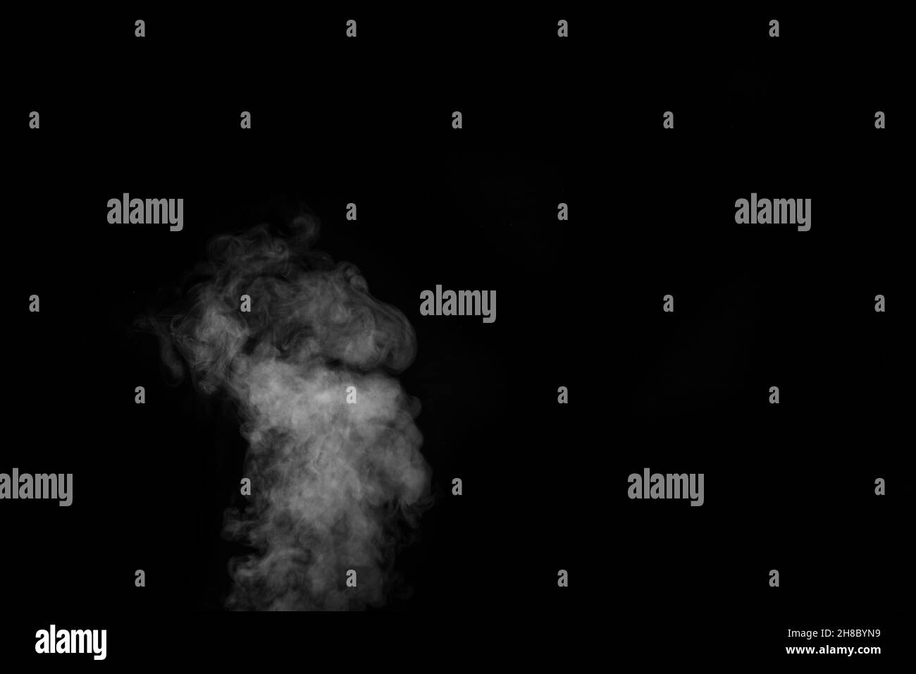 Weißer Dampfsprühdampf aus dem Luftsättigungsgerät. Rauchfragmente auf schwarzem Hintergrund. Abstrakter Hintergrund, Design-Element, für Überlagerung auf Bildern Stockfoto
