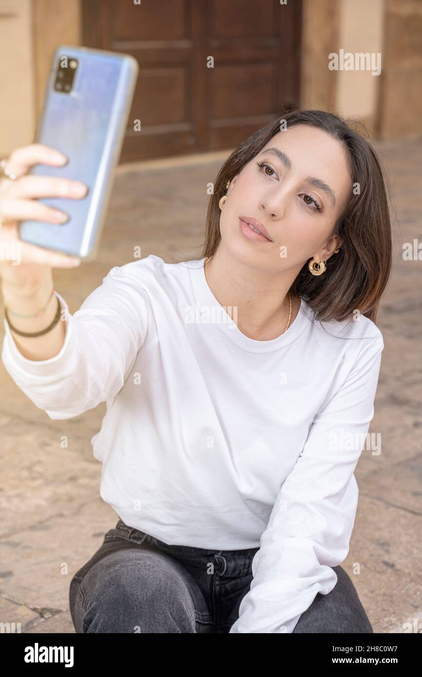 Porträt einer jungen Frau, die mit dem Mobiltelefon fotografiert Stockfoto