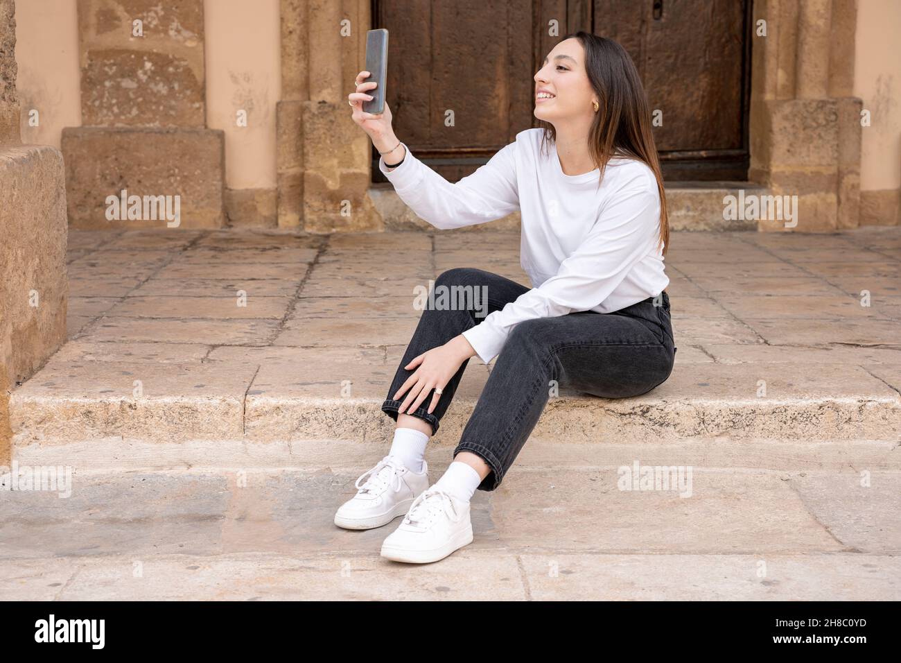Junge lächelnde Frau der tausendjährigen Generation sitzt Selfie machen Stockfoto