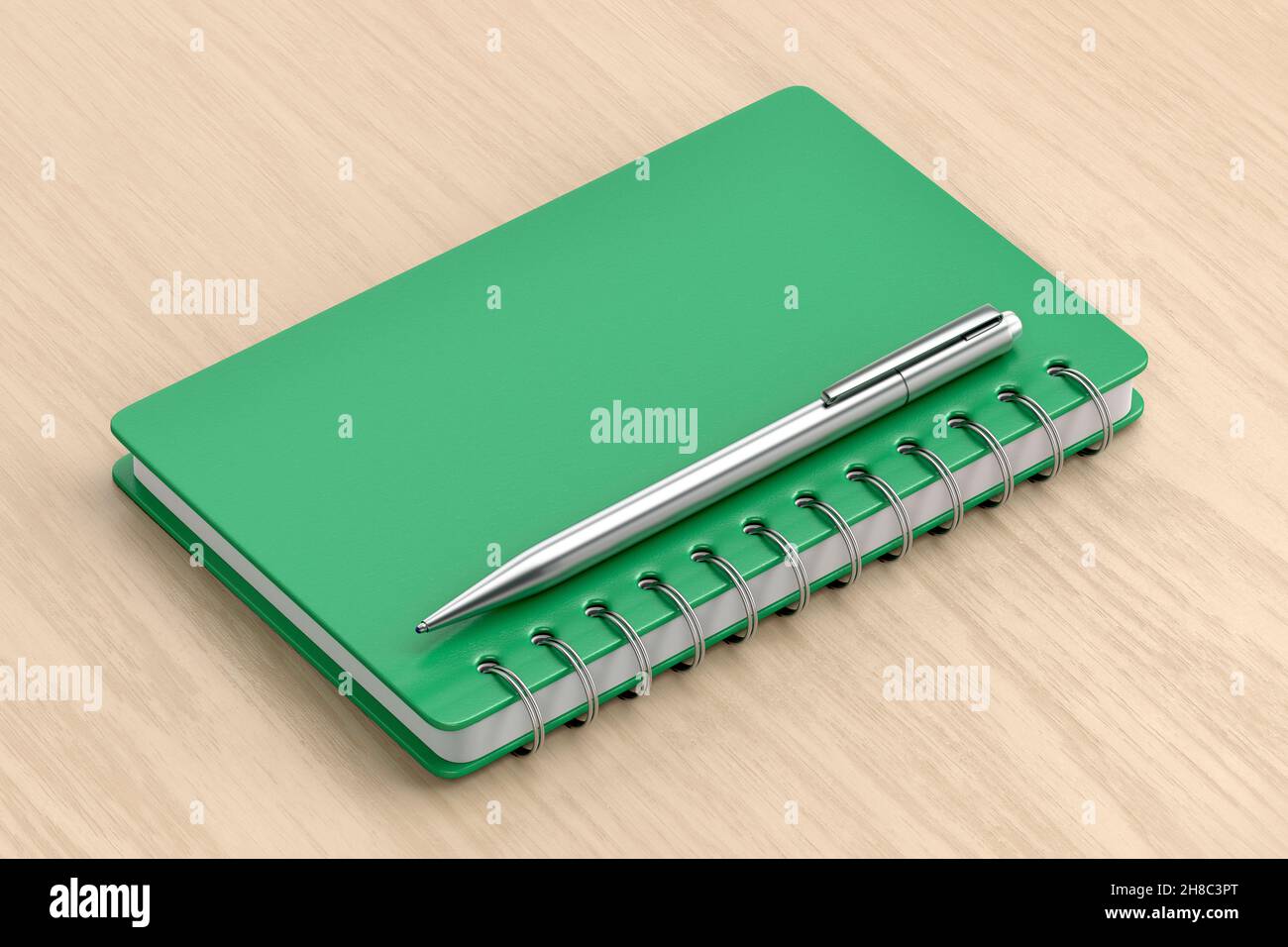 Grünes Spiralheft und silberner Stift auf Holztisch Stockfoto