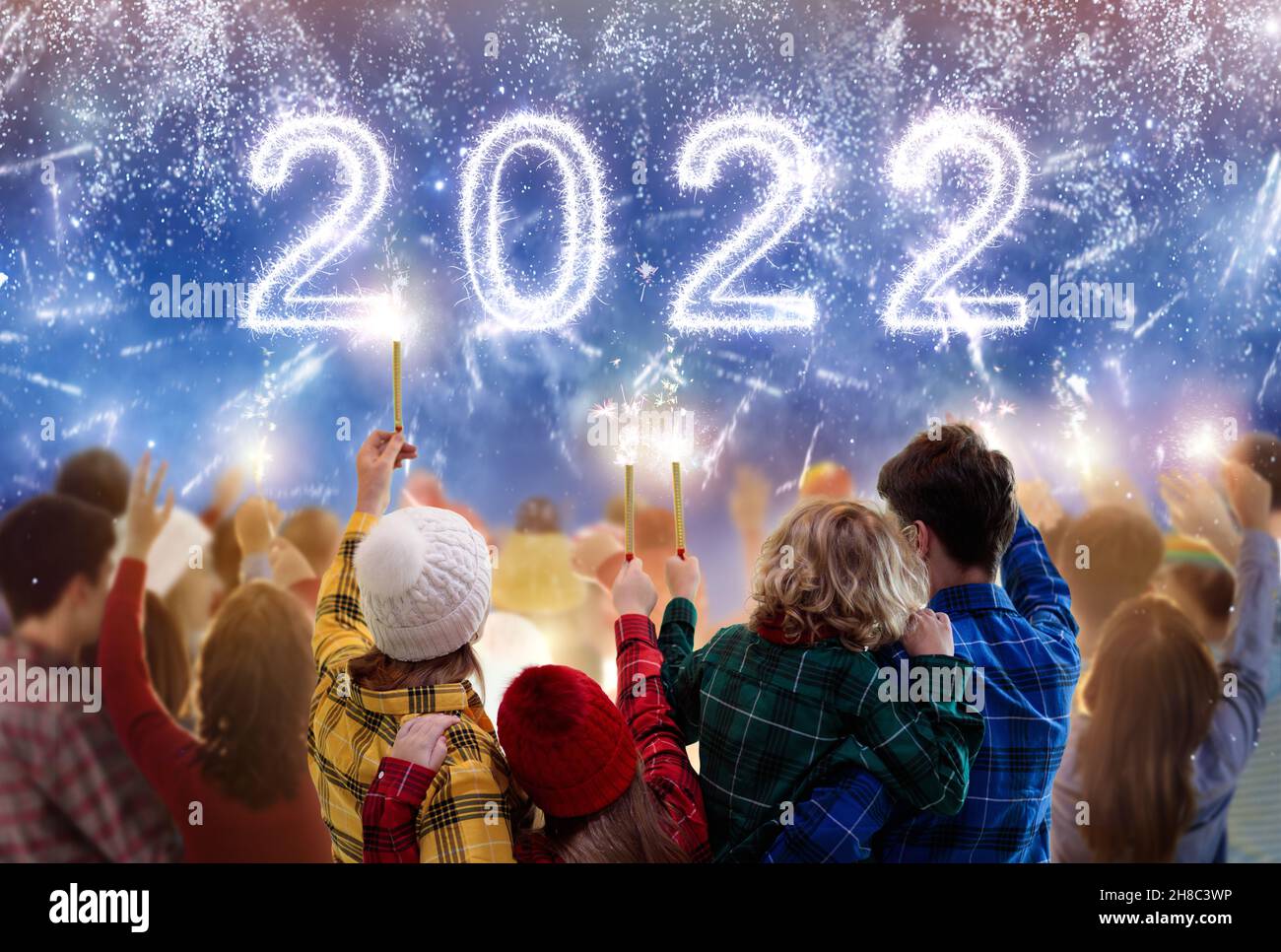 Frohes neues Jahr. Familienfeuerwerk. Eltern und Kinder feiern das neue Jahr 2022. Winterurlaub Party. Spaß im Freien. Kinder, Mutter und Vater Stockfoto