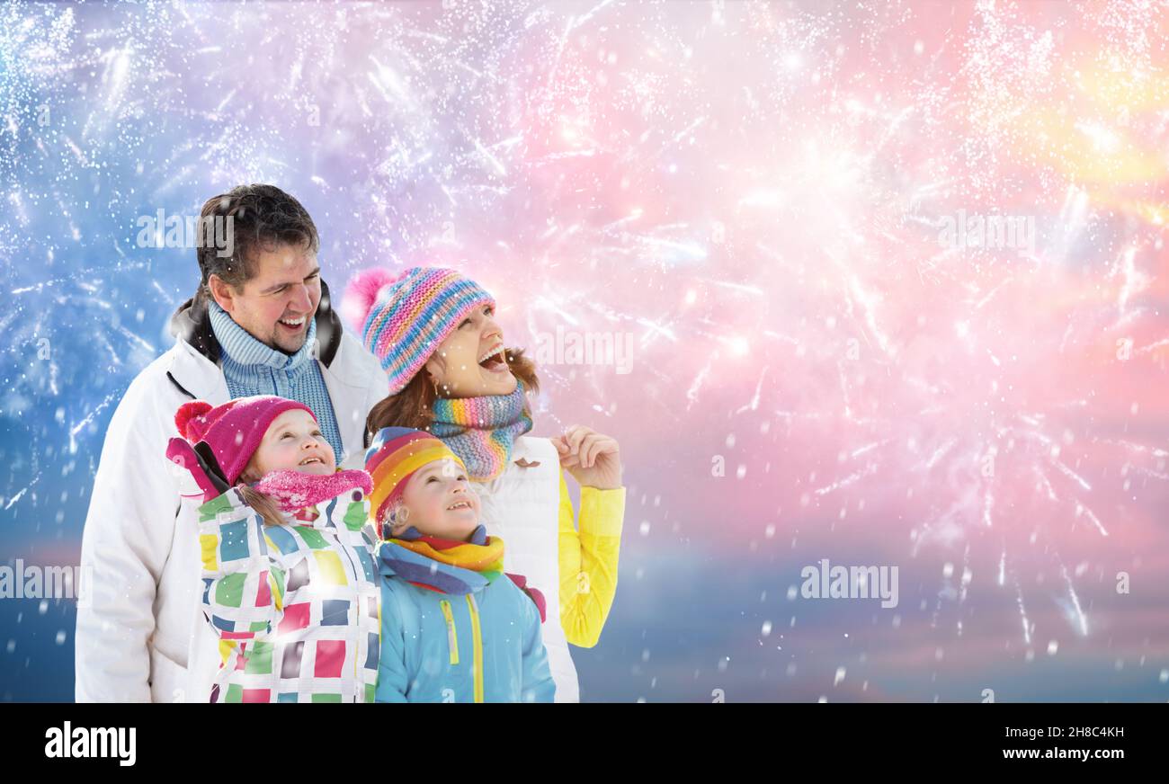 Frohes neues Jahr. Familienfeuerwerk. Eltern und Kinder feiern das neue Jahr 2022. Winterurlaub Party. Spaß im Freien. Kinder, Mutter und Vater Stockfoto