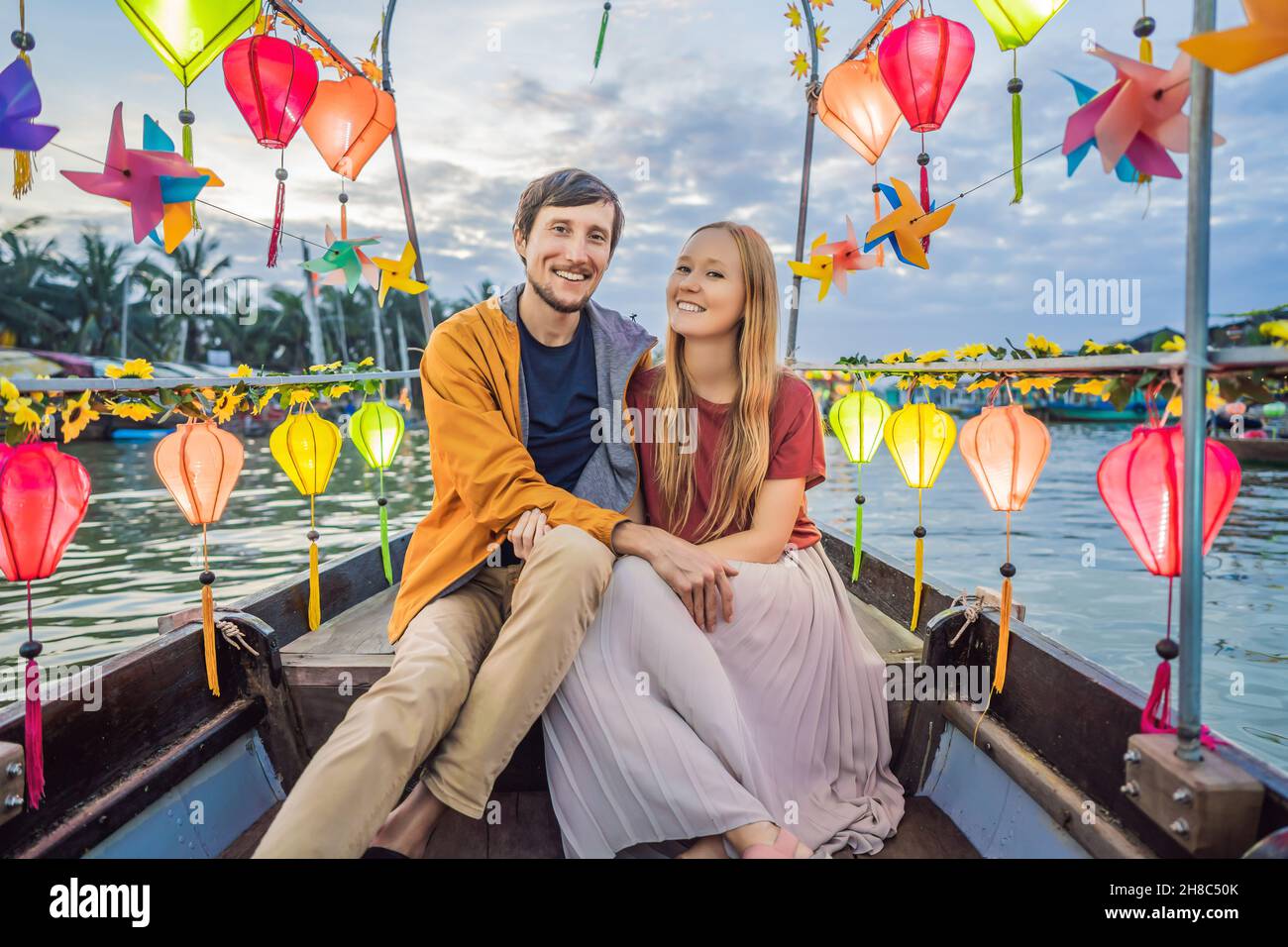 Ein glückliches Paar von Reisenden fährt auf einem Nationalboot auf dem Hintergrund der alten Stadt Hoi in Vietnam. Vietnam öffnet sich nach der Quarantäne wieder für Touristen Stockfoto