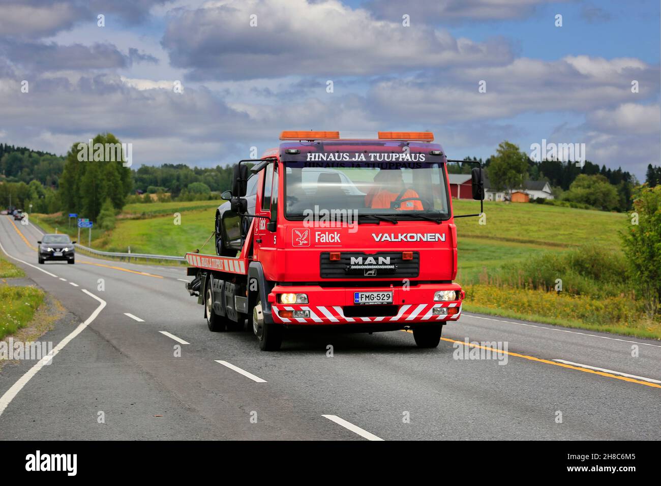 Straßenlandschaft mit MANN Flachbett Bergefahrzeug von hinaus ja Tuuppaus Antti Valkonen mit beschädigten Auto. Ikaalinen, Finnland. August 12, 2018. Stockfoto