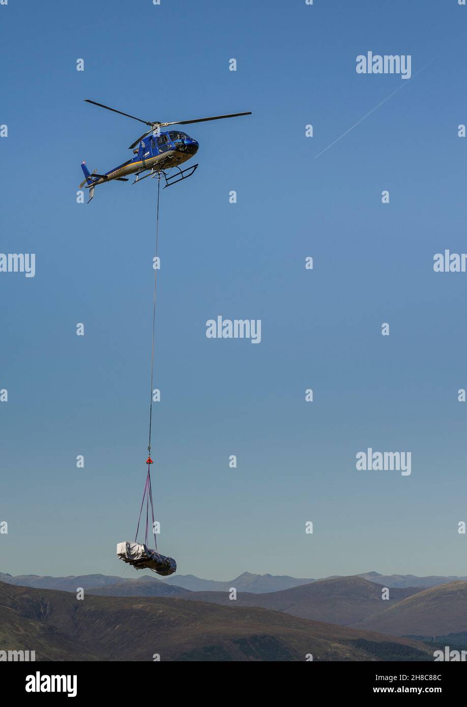 Skyhook-Hubschrauber, der Material zur Bergstation der Nevis Range Mountain Experience-Seilbahn transportiert, um die Besuchereinrichtungen zu entwickeln. Stockfoto