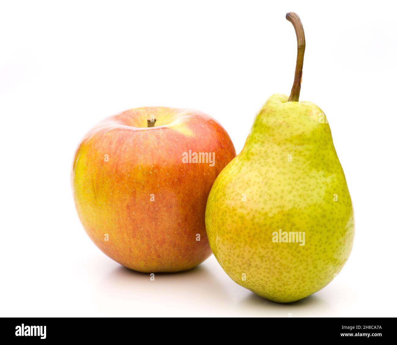 Vergleichen Sie Äpfel mit Birnen, die sich aneinander lehnen Stockfoto