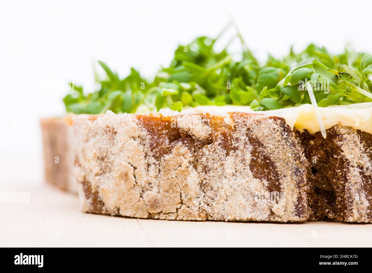 Detail von gebuttertem Brot mit Kresse auf einem Holzbrett Stockfoto