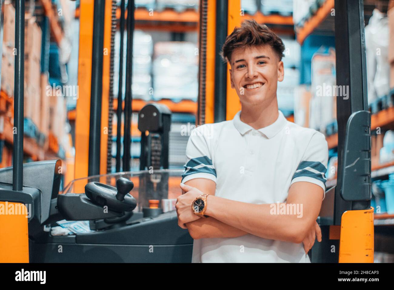 Mann in einem Geschäft neben einem Gabelstapler in einem Geschäft Stockfoto