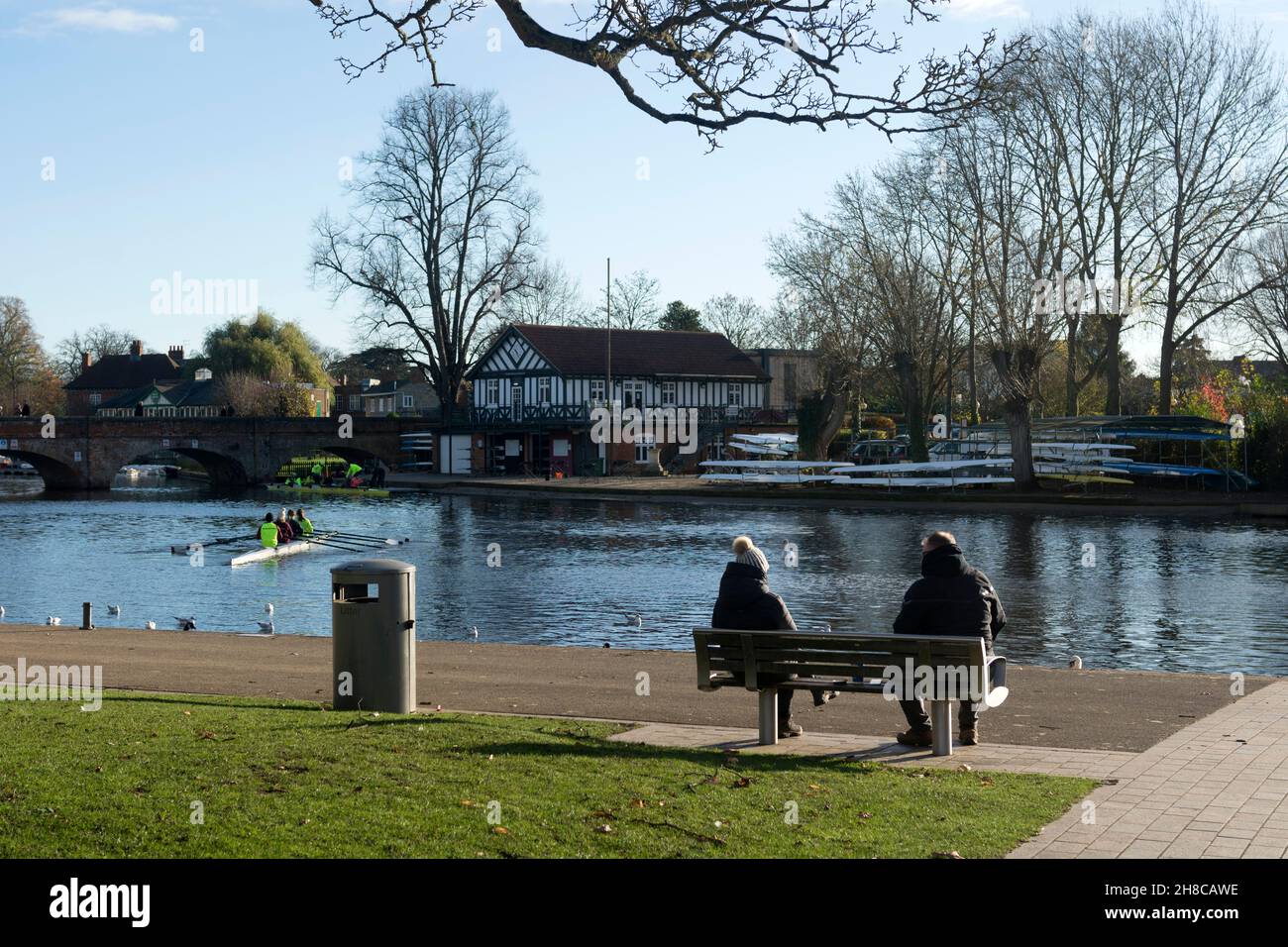 Zwei Personen saßen im November auf einer Bank mit Blick auf den Fluss Avon, Stratford-upon-Avon, Warwickshire, England, Großbritannien Stockfoto