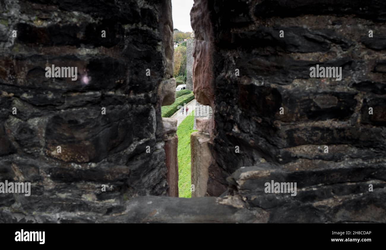 Pfeilspalt in der Befestigungsmauer, die die mittelalterliche Stadt Conwy, Wales, umgibt Stockfoto