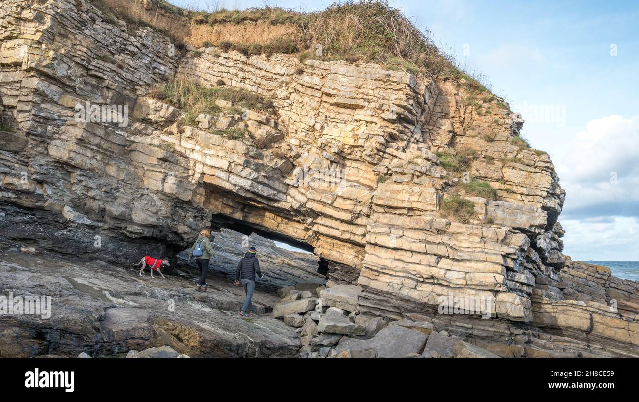 Der Tunnel unter einer Klippe, die eine Brücke in Penmon, Anglesey, Wales bildet. Stockfoto
