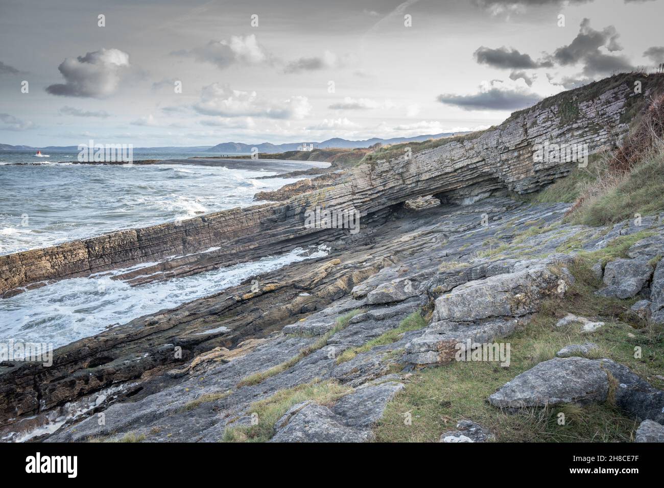 Der Tunnel unter einer Klippe, die eine Brücke in Penmon, Anglesey, Wales bildet. Stockfoto