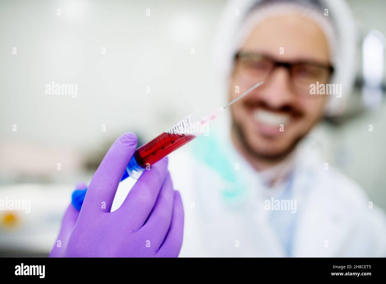 Nahaufnahme einer Ärzte Hand halten Spritze mit Blut. Blutanalyse im Labor. Stockfoto