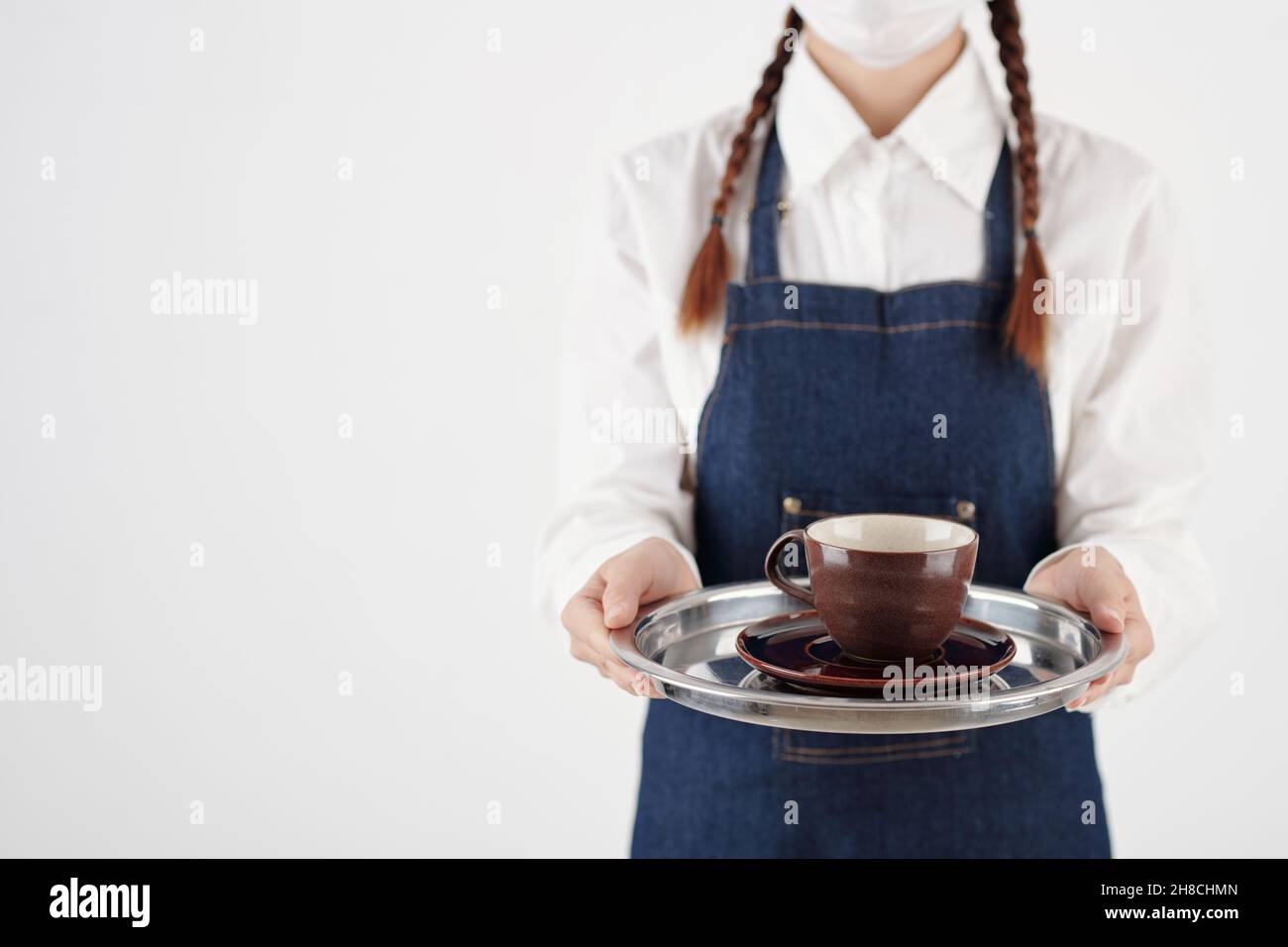 Zugeschnittenes Bild einer Barista, die das Tablett mit einer Tasse Kaffee oder Tee hält Stockfoto