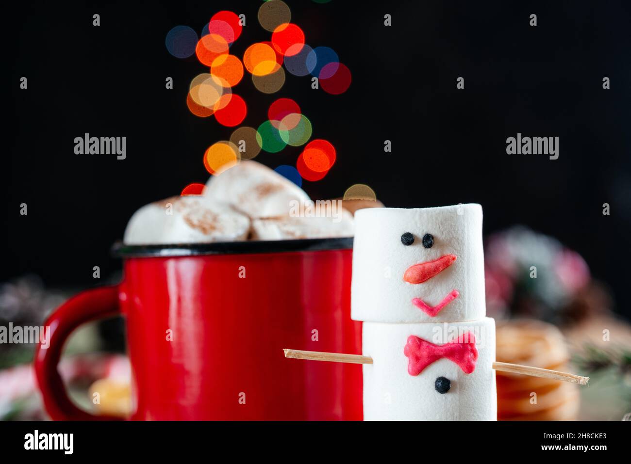 Rote emaillierte Tasse mit heißer Schokolade und Schneemann auf Weihnachtshintergrund Stockfoto