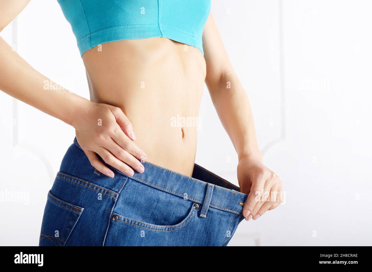 Kaukasische weibliche model in Blue Jeans Ihr flacher Bauch zeigt. Weightloss Konzept. Stockfoto