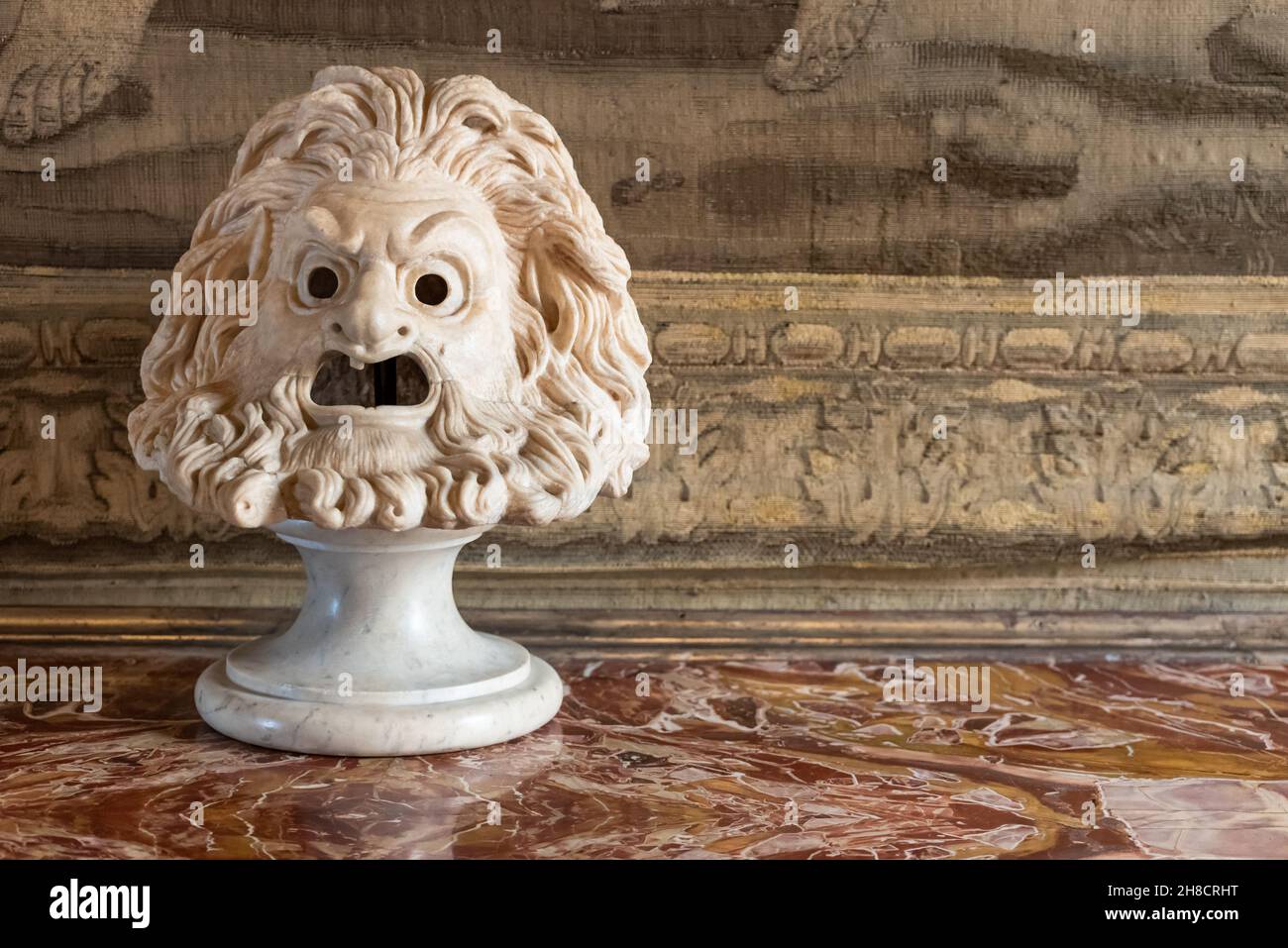 Nahaufnahme einer antiken Marmorskulptur, die ein hässliches und wütendes männliches Gesicht darstellt Stockfoto