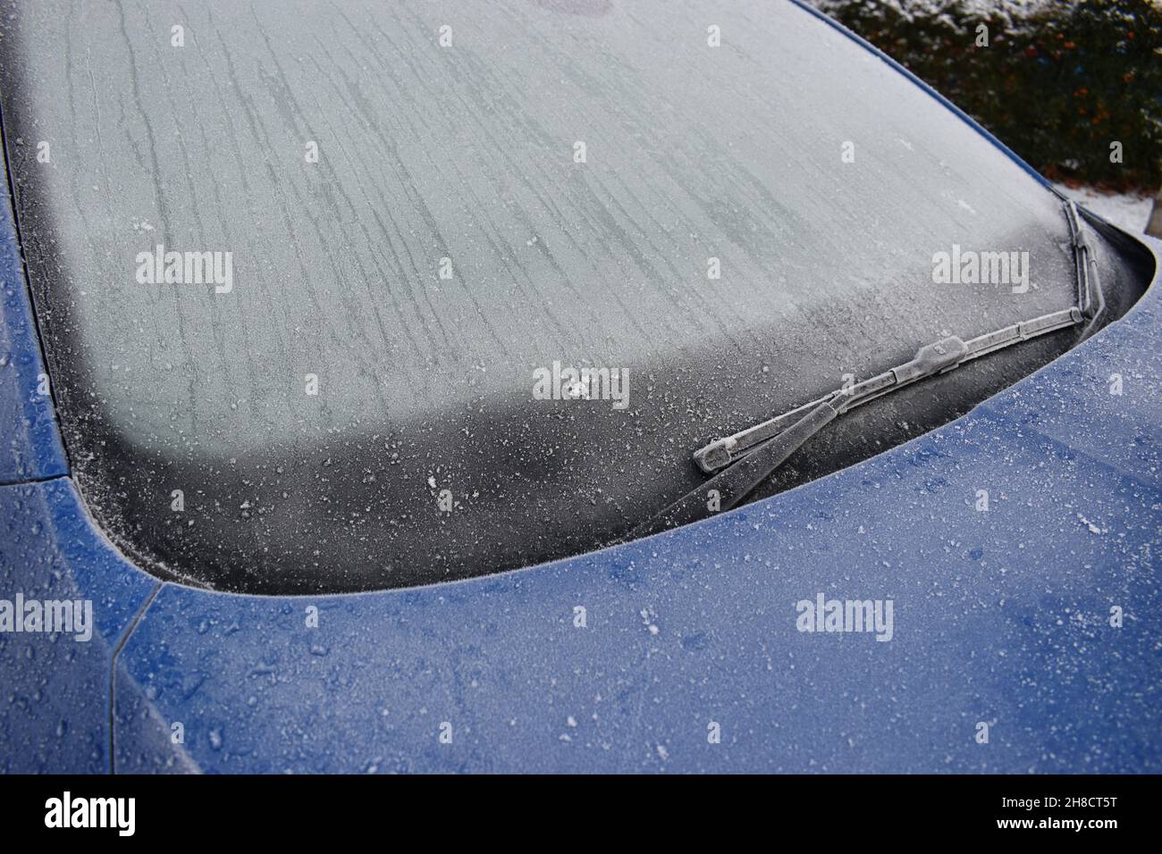 Die gefrostete Windschutzscheibe eines Autos an einem Wintermorgen. Eine  Schutzmatte schützt vor Frost an der Windschutzscheibe Stockfotografie -  Alamy