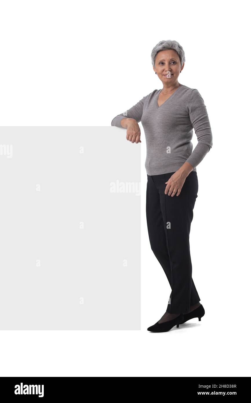 Reife asiatische Geschäftsfrau hält leeren Text Zeichen über weißem Hintergrund Stockfoto