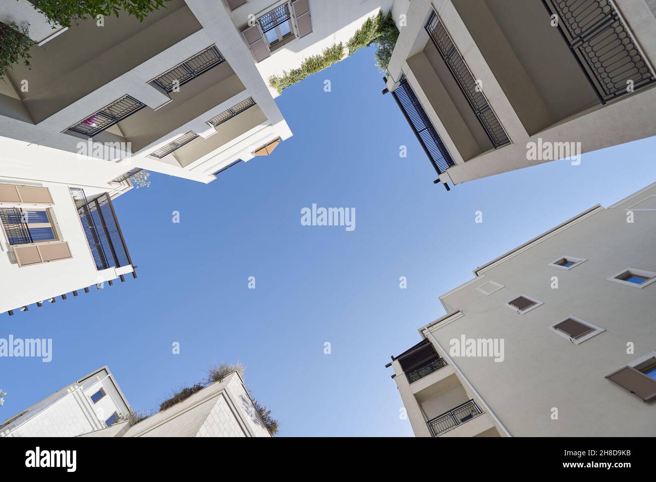 Blick aus niedrigen Winkeln zwischen Wohngebäuden und Himmel Stockfoto Blick aus niedrigen Winkeln zwischen Wohngebäuden und Himmel Stockfoto