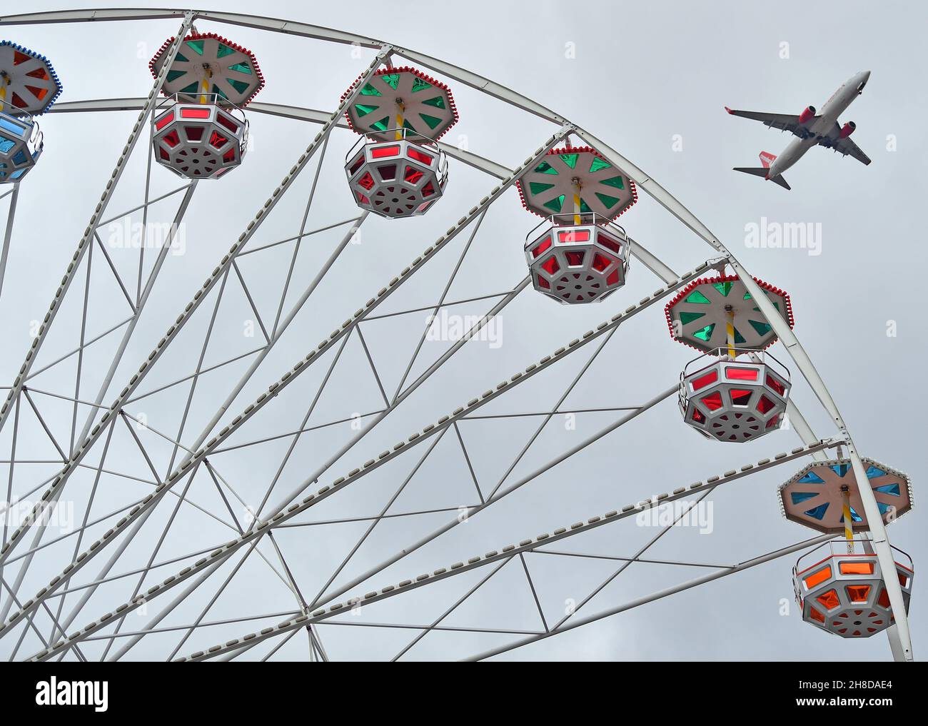 29. November 2021, Thüringen, Erfurt: Ein Flugzeug im Anflug fliegt über das Riesenrad auf dem Domplatz. Der traditionelle Markt wurde am 23. November eröffnet und am 24. November aufgrund der aktuellen Corona-Verordnung geschlossen. Angesichts der Streichung vieler Weihnachtsmärkte hat der Deutsche Schausteller-Verband massive staatliche Finanzhilfen gefordert. Foto: Martin Schutt/dpa-Zentralbild/dpa Stockfoto