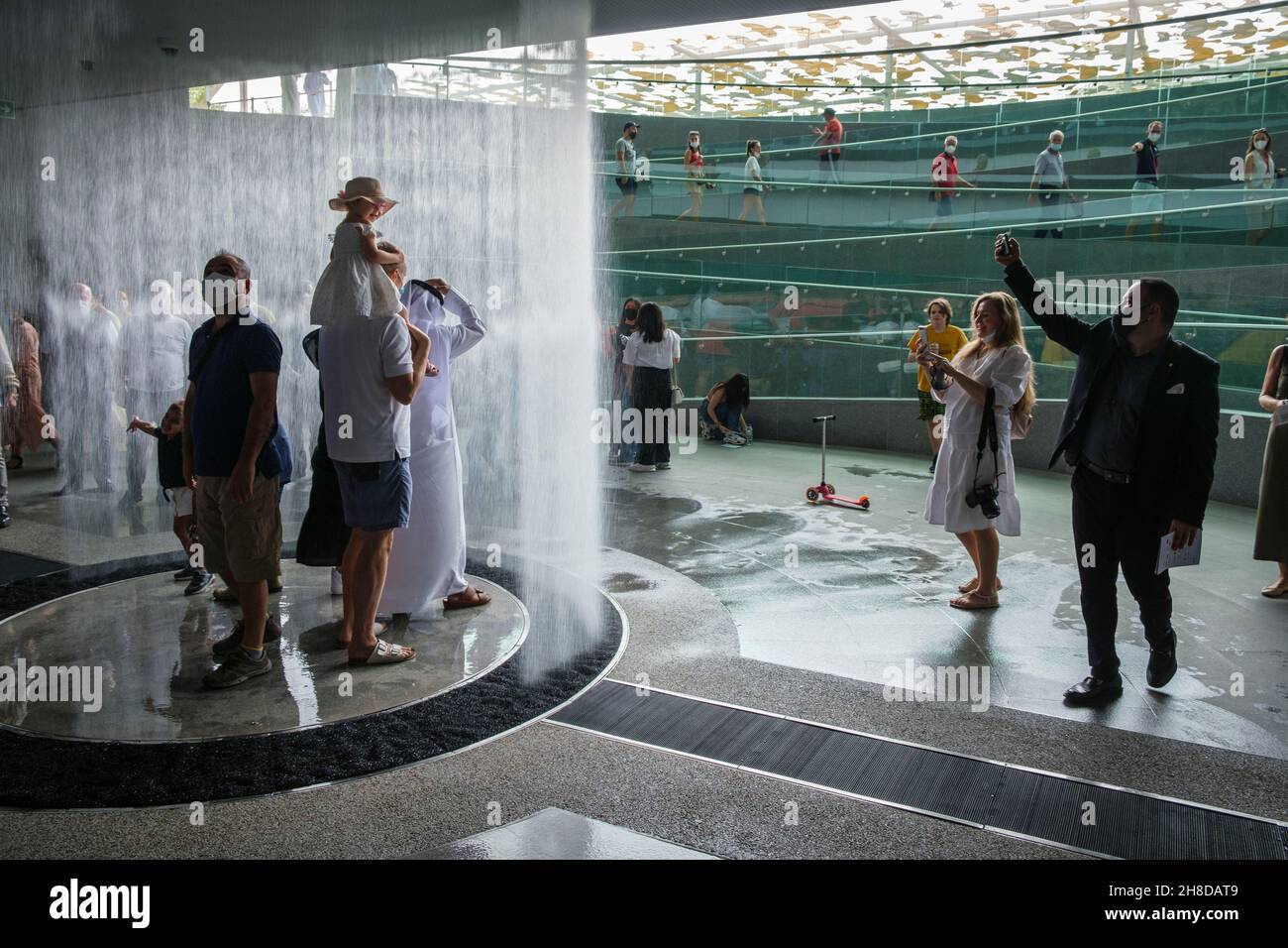 Besucher stehen unter dem Wasserfall im Eingang zum Pavillon des Königreichs Saudi-Arabien, Expo 2020, Dubai Stockfoto
