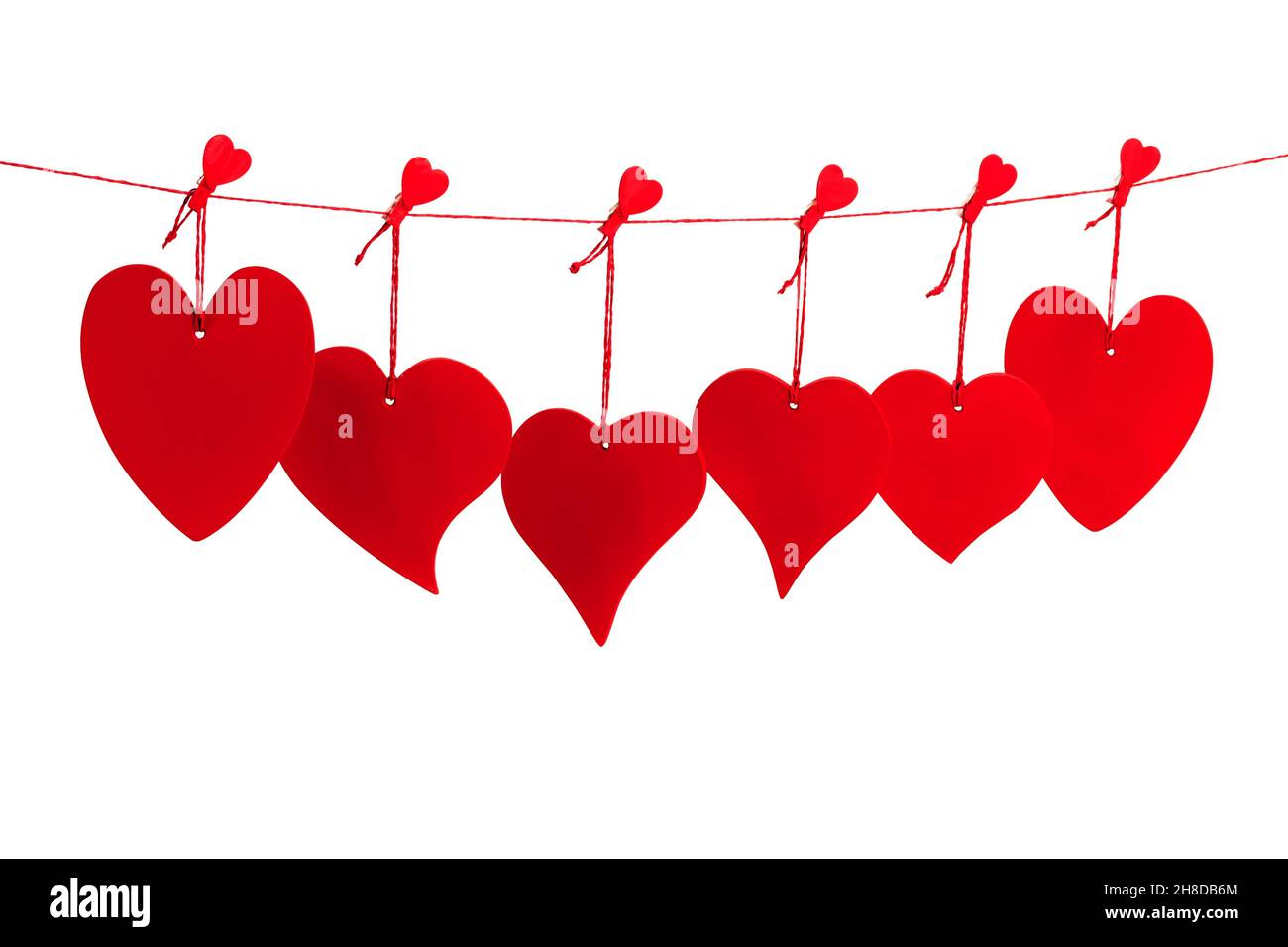 Sechs rote Valentine Herzen hängen von einer roten Schnur isoliert auf weißem Hintergrund Stockfoto
