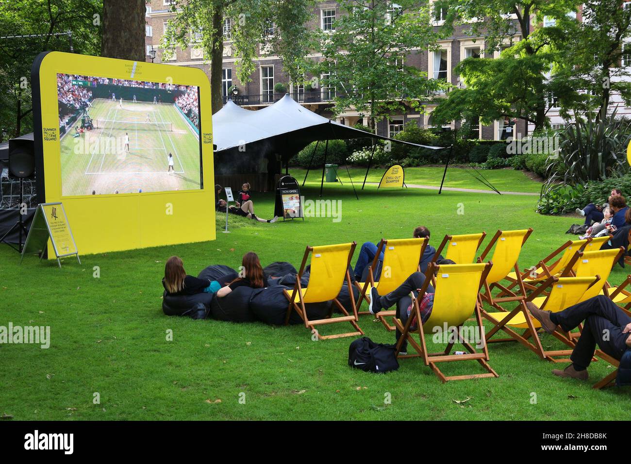 LONDON, Großbritannien - 7. JULI 2016: Leute genießen öffentlichen Wimbledon Tennis Turnier Broadcast im Grosvenor Square Park von London, Großbritannien. Stockfoto