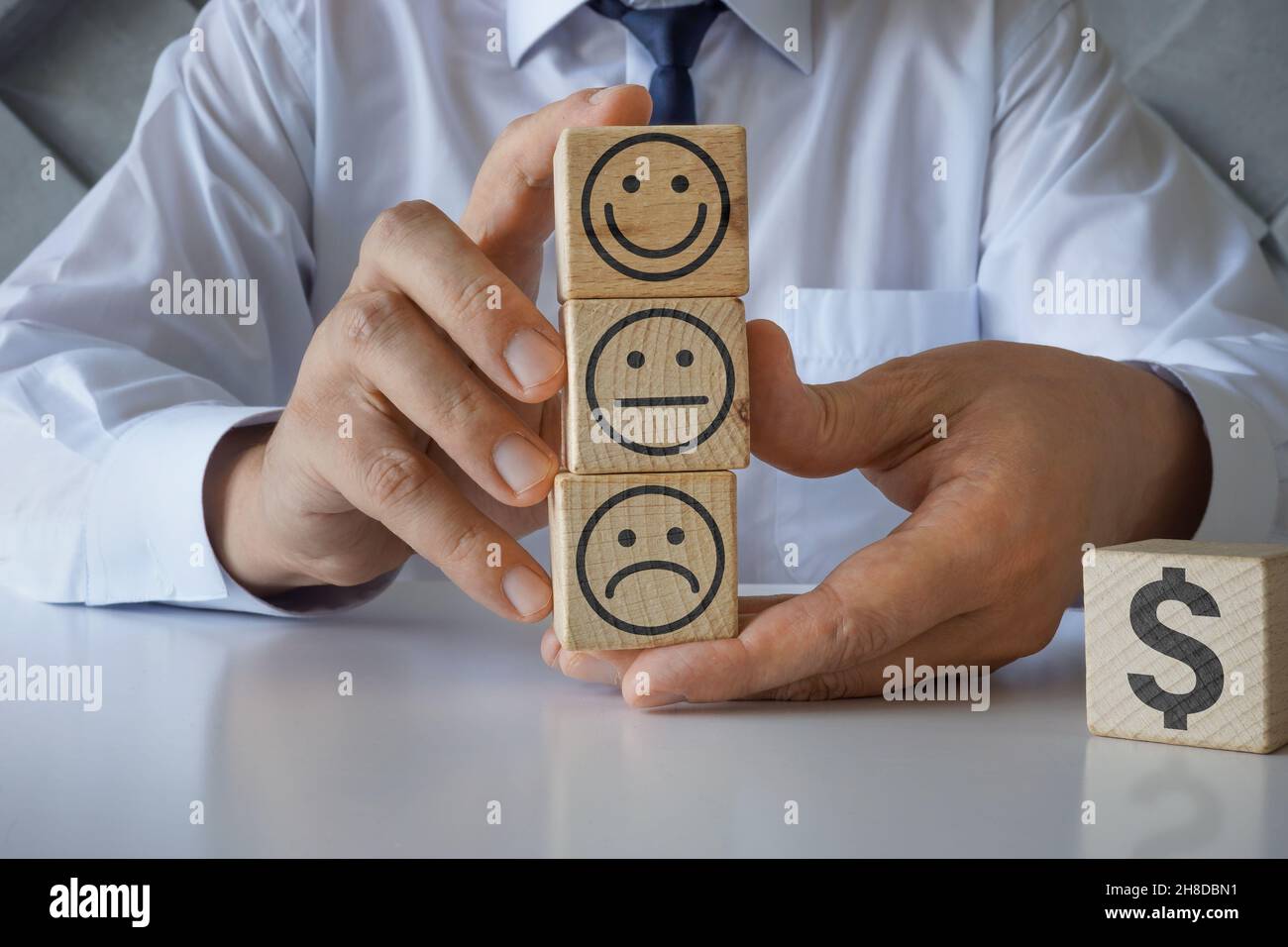 Holzwürfel mit lächelnden Gesichtern. Customer Experience Management-Konzept. Stockfoto