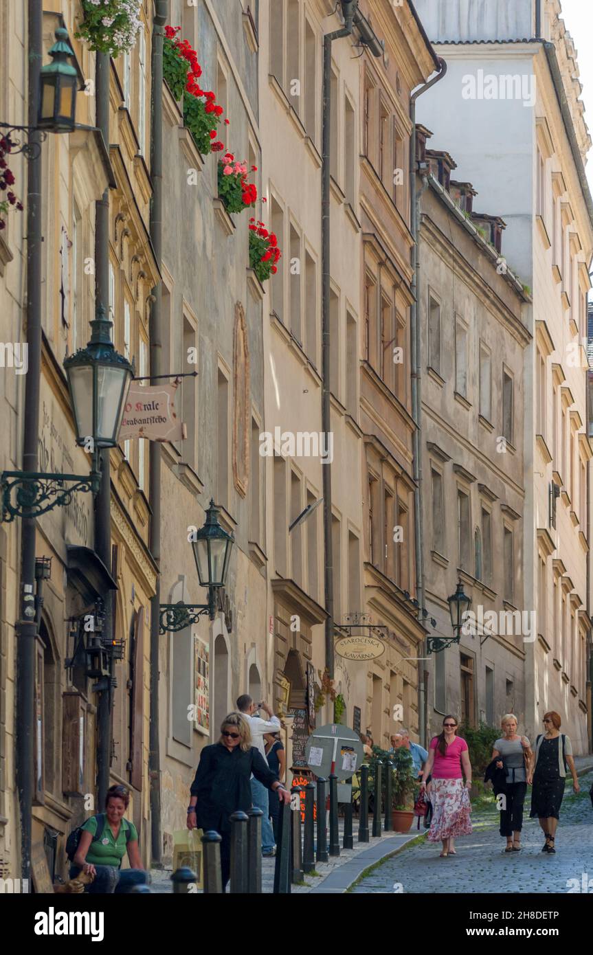 Leuchtend rote Fensterkästen verleihen den hohen Steingebäuden an der schmalen Thunovská-Straße in der Prager Kleinseite einen Hauch von Farbe. Stockfoto