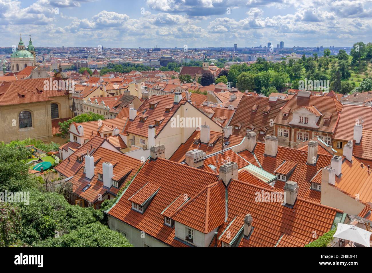 Die orangefarbenen Terrakotta-Dächer des Prager Viertels Malá Strana erstrecken sich an der Nikolaikirche entlang bis zur Moldau und darüber hinaus. Stockfoto