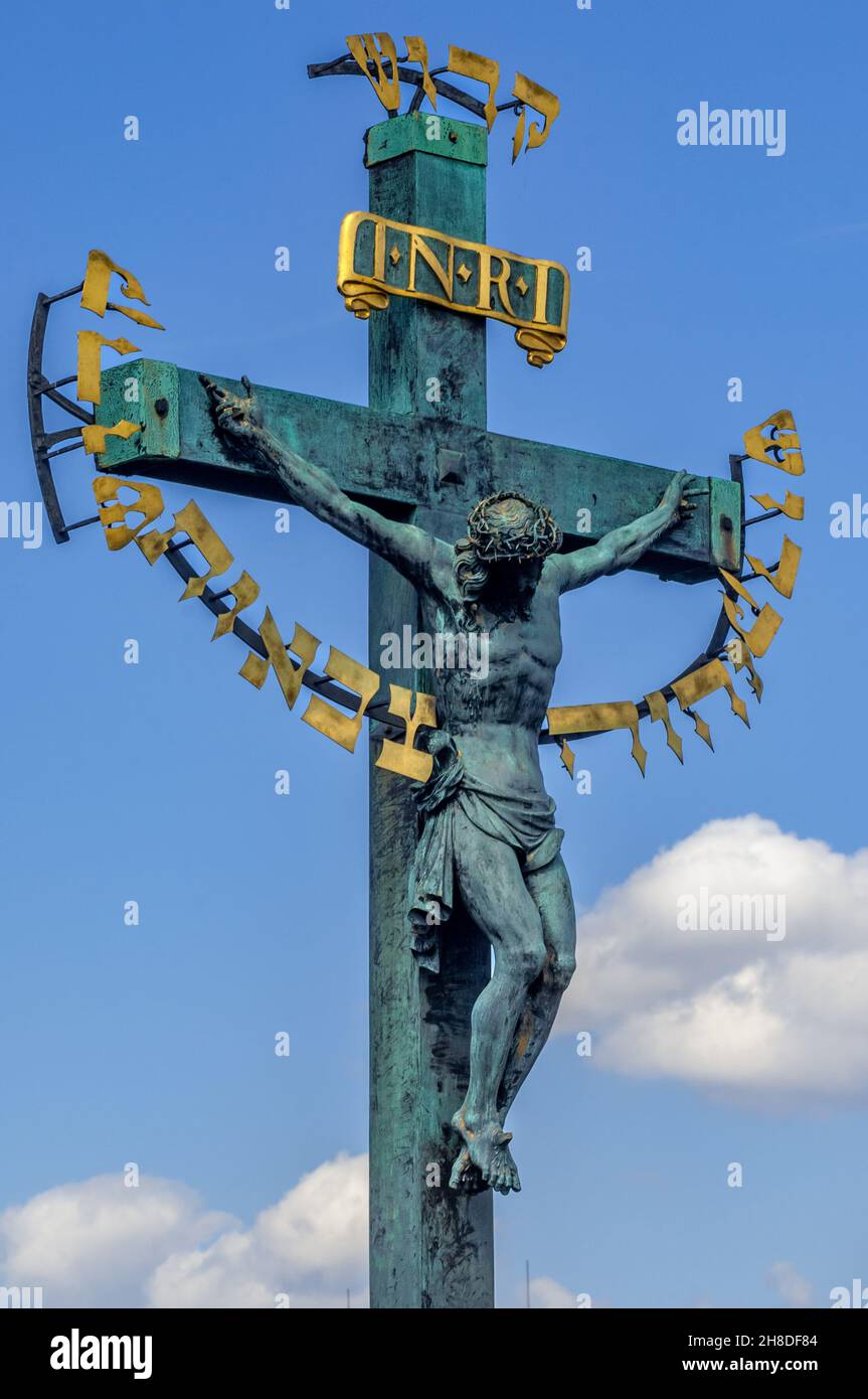 Das Kruzifix von H. Hillger aus dem Jahr 1629 und die Kalvarienstatuar auf der Karlsbrücke.der goldene hebräische Text auf dem Kruzifix wurde 1696 hinzugefügt Stockfoto