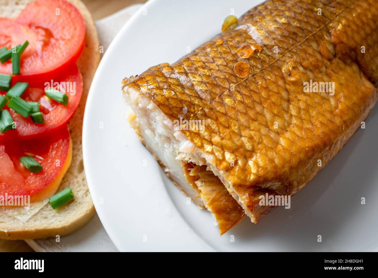 Geräucherter Weißfisch auf einem Teller mit Tomaten-Sandwich Stockfoto
